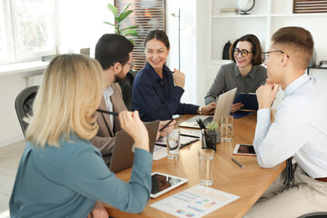 Fototapeta premium Coworkers working together at wooden table in office