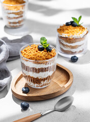 Russian honey cake Medovik trifle layered and decorated with blueberries. Sponge honey cakes with sour cream.