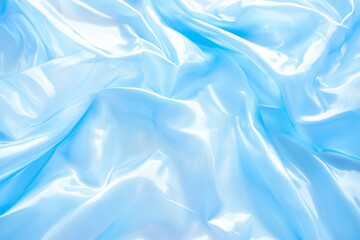 Fototapeta premium Shiny smooth light blue silk fabric with elegant folds and soft highlights captured in close-up, creating a luxurious and calming aesthetic in pastel fashion or textile design concept 