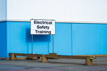 industrial building exterior with electrical safety training sign.