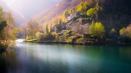 Fototapeta premium Isola Santa ancient village and the lake in autumn. Long exposure photo, Garfagnana, Tuscany, Italy.