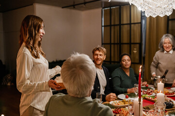 A multinational group of people of different ages, a White young blonde woman holding a basket at a...