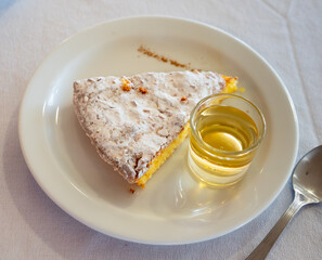 Traditional spanish almond pie Tarta de Santiago with glass of drink