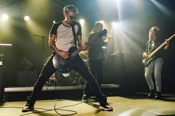 Guitarist performing with band on stage during music concert