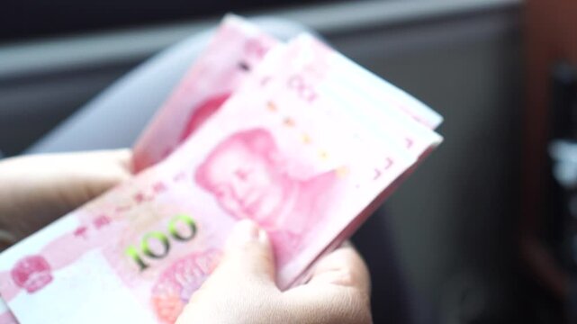 Chian yuan cash money one hundred Chinese yuan bills, yuan banknotes Chinese currency (Renminbi or RMB) featuring 100-yuan banknote with Mao Zedong's for goods services, Cash on car