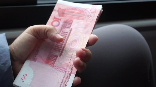 yuan banknotes Chinese currency (Renminbi or RMB) featuring 100-yuan banknote with Mao Zedong's. Counting cash money one hundred Chinese yuan bills for goods services, Cash in car