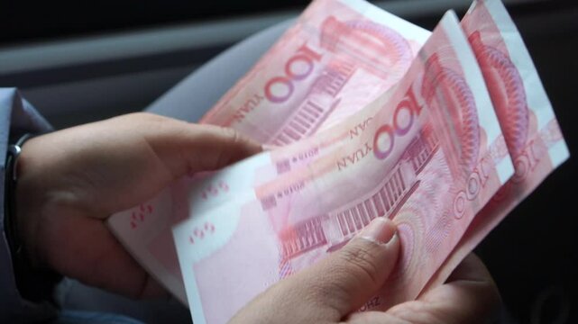 Chian yuan cash money one hundred Chinese yuan bills, yuan banknotes Chinese currency (Renminbi or RMB) featuring 100-yuan banknote with Mao Zedong's for goods services, Cash on car
