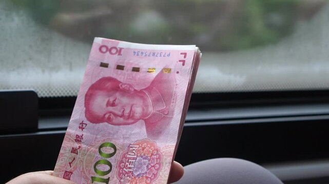 yuan banknotes Chinese currency (Renminbi or RMB) featuring 100-yuan banknote with Mao Zedong's. Counting cash money one hundred Chinese yuan bills for goods services, Cash in car