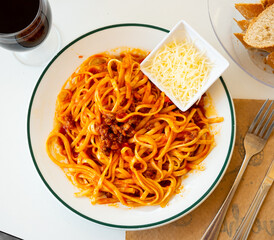 Italian tallarines bolonesa, bolognese noodles with tomato sauce and cheese in a cafe