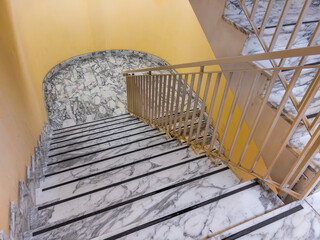 .Marble staircase with curved landing and painted iron railing