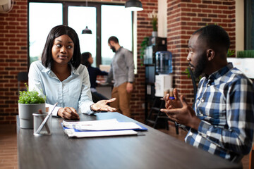 Young black woman explaining her work experiences and expectations to professional hiring manager....