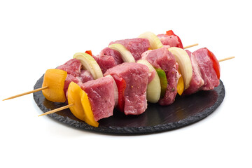 Raw meat skewers with vegetables isolated on white background.