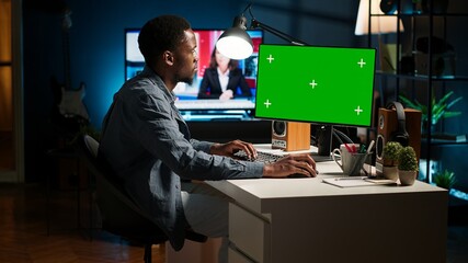 Male freelancer sitting at his desk with copy space screen on computer, browsing the web and enjoys...