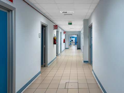 Corridor of Italian hospital with red fire extinguishers hanging on the walls