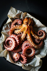A creatively arranged octopus dessert sits on a plate, surrounded by crumpled paper towels and a paper bag, evoking a whimsical and playful atmosphere