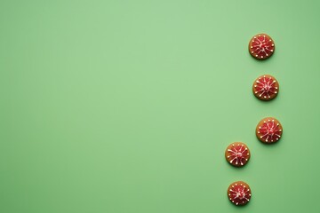 Christmas gingerbread cookies with red and white icing on a green background