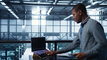 Technician in data center with laptop and tablet integrating AI driven automation tools. Server room worker using artificial intelligence on devices, ensuring continuous uptime, camera B