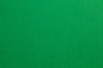 A green background with a few specks of white, textured origami paper backdrop