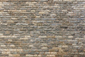Patterned gray stone brick wall texture with varied shades and surfaces
