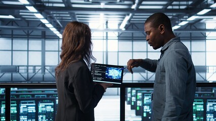 Software developers in data center use AI technology on tablet to optimize storage volumes. IT...