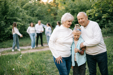 28.09.24 Vinnitsa, Ukraine: Grandparents with their children and grandchildren in front of them during a family photo shoot in the garden