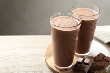 Tasty chocolate milk and bars on wooden table. Space for text