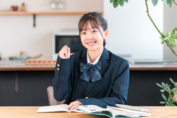 家で勉強する制服姿の小学生,中学生,高校生の女の子
