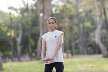 A enthusiastic Asian sports woman stopped after exercising at the garden, sitting on a exercise...
