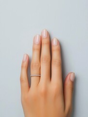 Close-up of a woman's hand with a ring on her ring finger. the ring is made of silver and has a thin band with small diamonds embedded in it.
