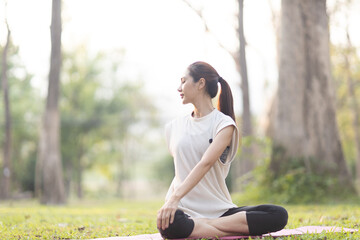 A enthusiastic Asian sports woman stopped after exercising at the garden, sitting on a exercise...