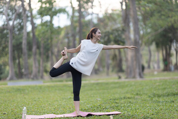 A enthusiastic Asian sports woman stopped after exercising at the garden, sitting on a exercise...