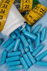 bottle of pills, some of which spilled onto a light blue surface