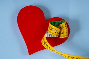 red heart shape with measuring tape symbolizing health care