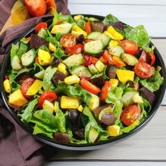 Delicious salad bowl filled with colorful veggies on a casual kitchen table set with a fork and napkin for enjoyment