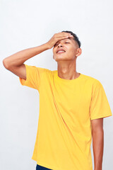 Asian Man in Yellow Shirt Expressing Frustration with a Hand to His Head