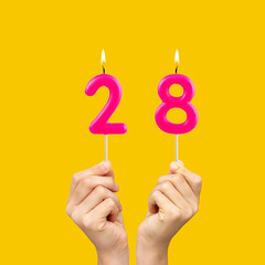 Birthday number 28 - Hands holding fuchsia colored candles