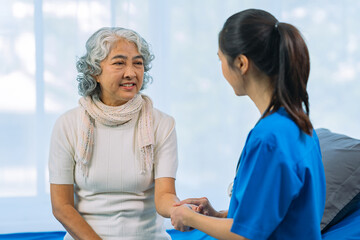 Obraz premium Asian female doctor consulting elderly patient at home, explaining diagnosis and treatment plan, providing health care to elderly woman, medical health concept
