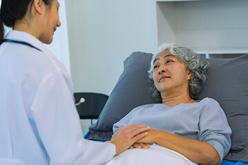 Fototapeta premium Asian female doctor consulting elderly patient at home, explaining diagnosis and treatment plan, providing health care to elderly woman, medical health concept
