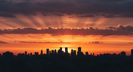 Obraz premium City Skyline Silhouette at Sunset with Orange Sky and Dramatic Clouds