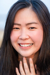 Close up to Young Asian Girl face, she is smiling and happy on rooftop at sunset time, twilight time.