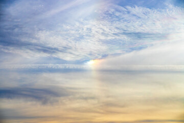 Fototapeta premium Optical effect of colored lights between the clouds of a blue sky