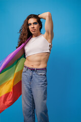 Genderless person waving the pride flag with a blue background and copy space