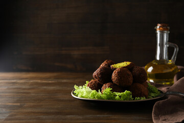 Falafel in a plate, on a dark background.