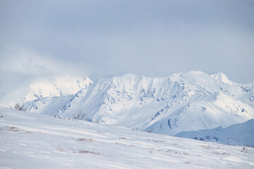 Snow on mountains on the Denali Highway on a sunny spring day in Alaska. 