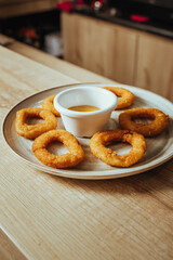 photo of crispy fried onion rings with mustard-based sauce in a Colombian cafeteria