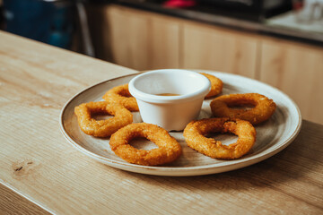 photo of crispy fried onion rings with mustard-based sauce in a Colombian cafeteria