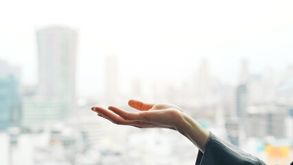 Woman holding her hands up against a city background