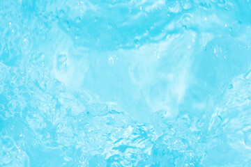 Blue water with ripples on the surface. Defocus blurred transparent blue colored clear calm water surface texture with splashes and bubbles. Water waves with shining pattern texture background.