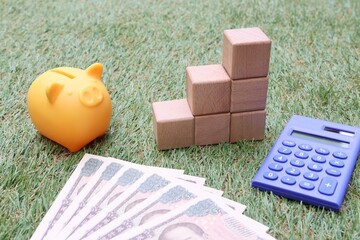 投資や貯金のイメージ　豚の貯金箱と積み立てられた積み木