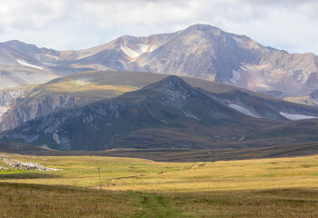 a trail on a rocky mountain plateau located on the path of a tourist route with an overview of the area